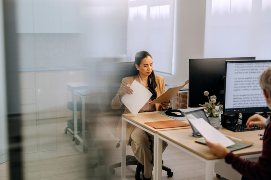 Professional reviewing recruitment documents with a colleague in a modern office.
