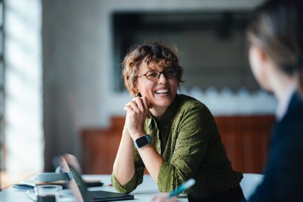 Person in discussion during a meeting in a modern office.