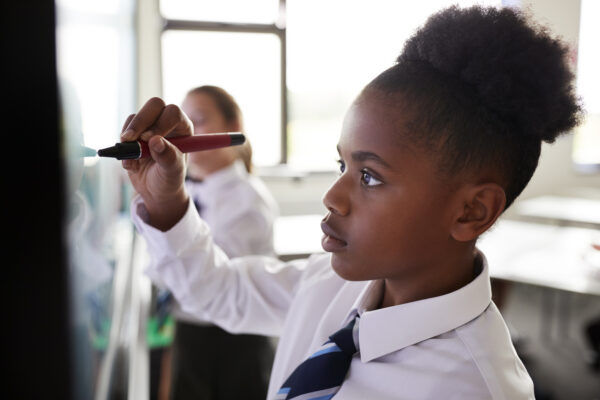 A school child writing in a classroom
